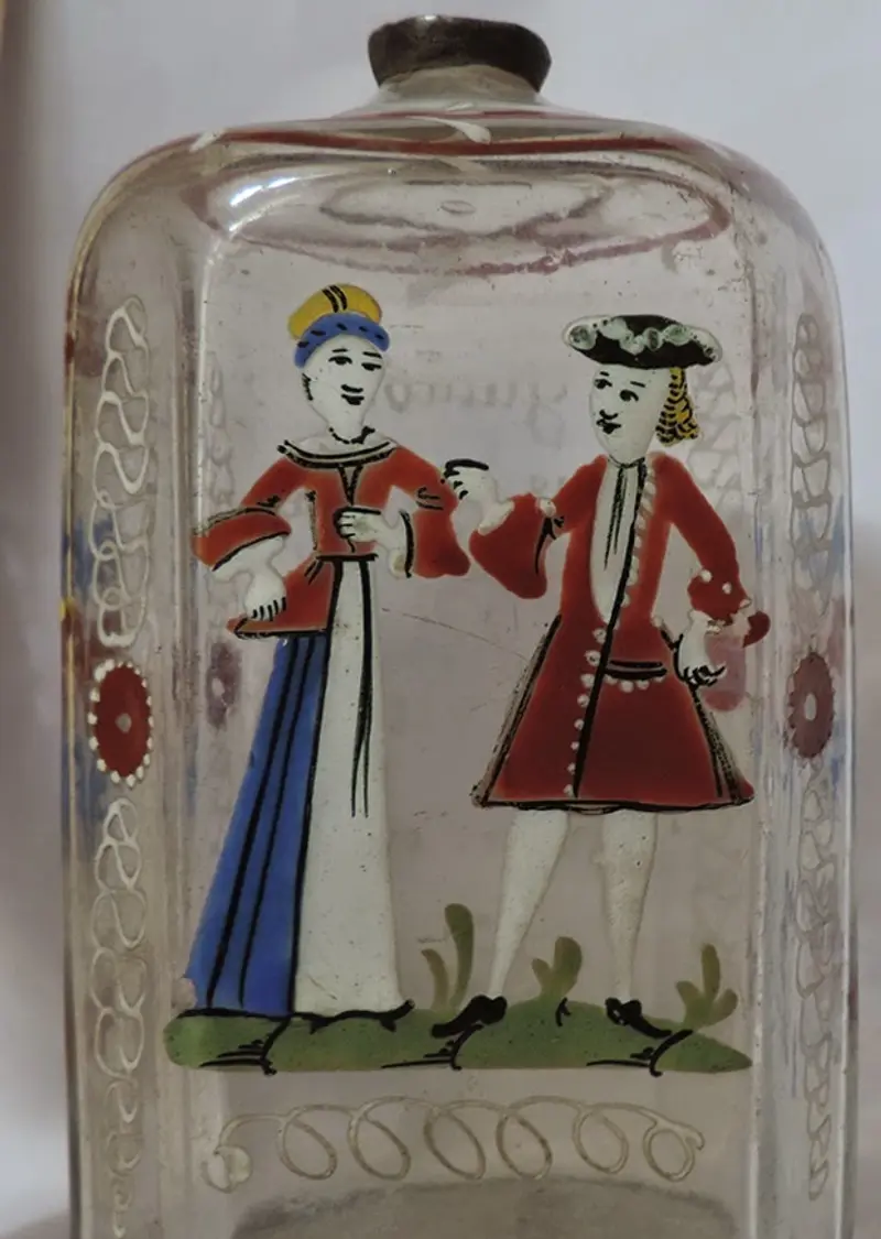 Divatos ruhákat viselő alakok az egyik 18. századi bájitalos üvegen. A kép forrása: mnit.ro 